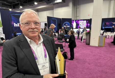 Photo of Jay Anders holding podcast award