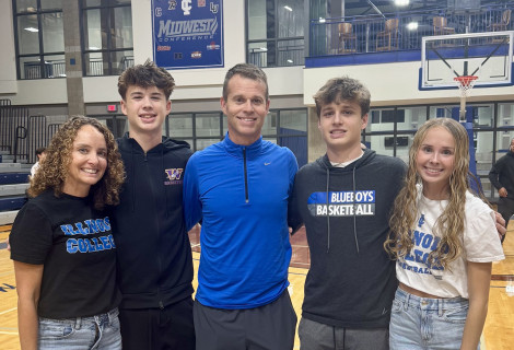 The Schoufler family posing on the basketball court